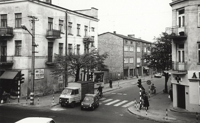 Zdjęcie przedstawia widok na&nbsp;skrzyżowanie ulic, widać samochody i&nbsp;budynki, w&nbsp;tym mały kiosk Ruchu