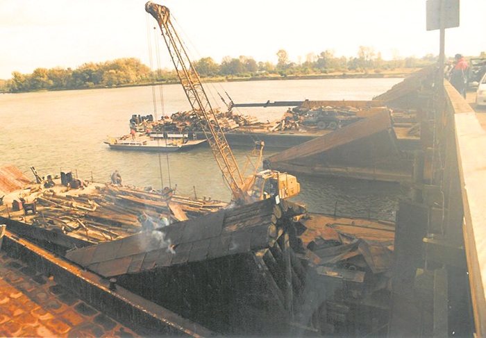 zdjęcie pzredstawia budowę mostu - widać dźwig i&nbsp;barkę z&nbsp;materiałami budowlanymi oraz&nbsp;betonowe przęsła