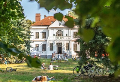 Pałac_w_Gawłowie, na pierwszym planie leżące na kocach na trawniku postacie